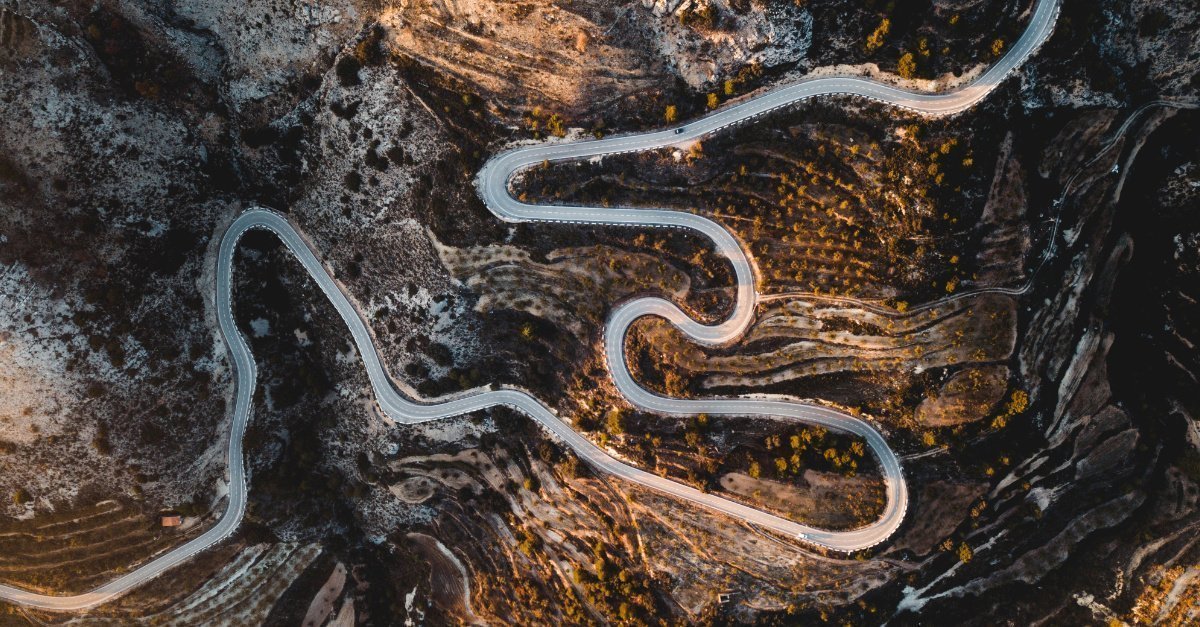 Vista aérea de una carretera sinusoidal entre montañas